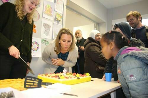 Bij Pino blaast twee kaarsjes uit. Schepenen Astrid De Bruycker en Sofie Bracke snijden de taart aan.