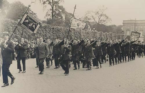 Foto uit 1924 van een optocht in Brussel waarbij door de delegatie van de ARAG de vlag van 'Buffalos Supportersclub' wordt meegedragen, met voor het eerst een afbeelding van een Inheemse Amerikaan. (Foto: AMSAB)