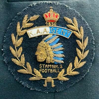 Naaiwerk voor op kostuumvest met het logo van de voetbalafdeling van de voetbalafdeling. Geproduceerd na de vernederlandsing van 1972. Als oprichtingsdatum wordt verkeerdelijk 1896 vermeld. (Foto: Collectie KAA Gent/KAA Gent Foundation)